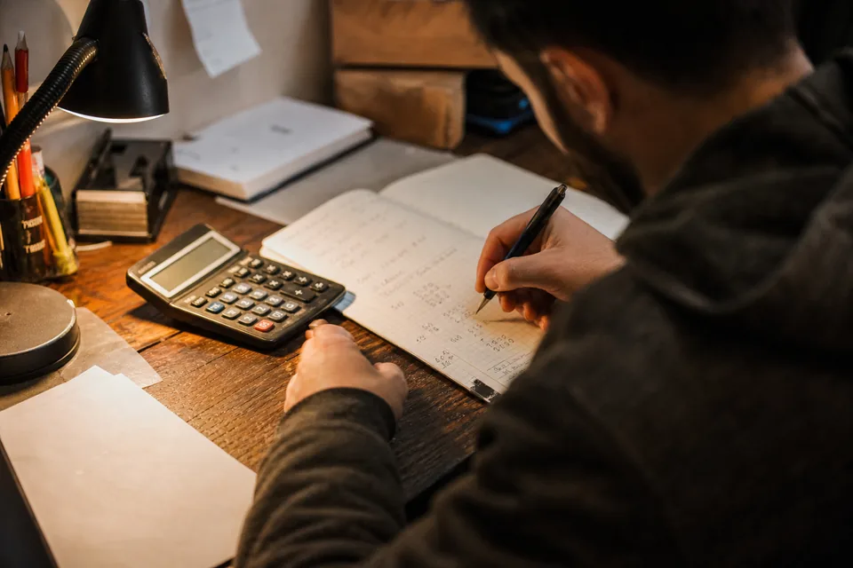 Calculator and notebook with handwritten numbers