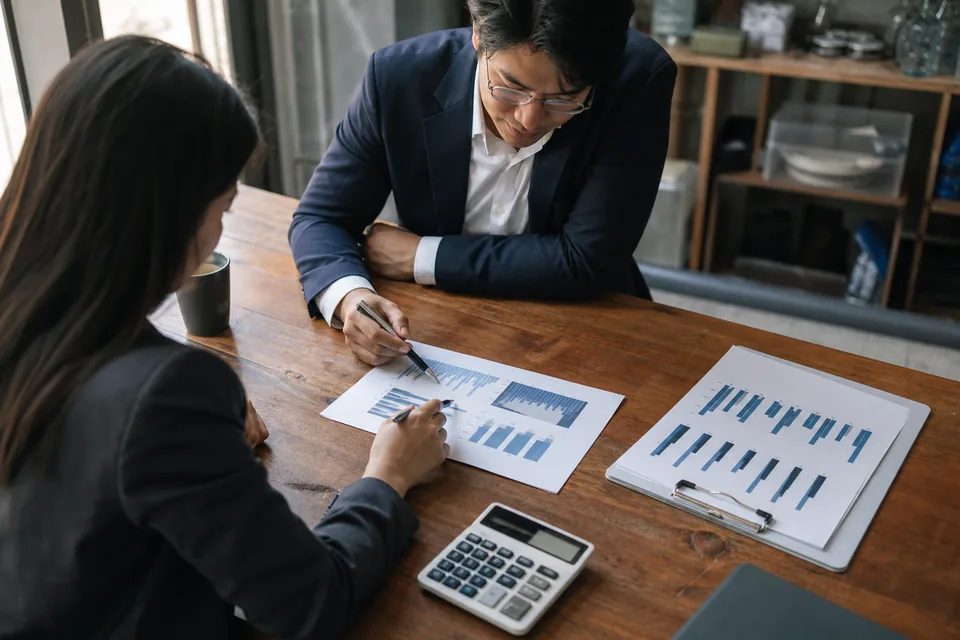 Finance team reviewing printed monthly revenue charts
